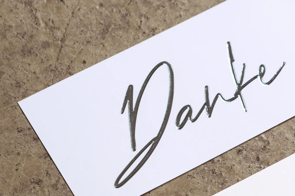 Schriftzug „Danke“ auf weißer Karte mit Glamprint silber