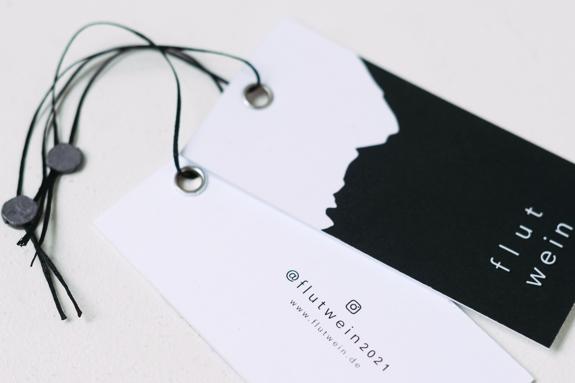 Flutwein-Hang Tags schwarz und weiss mit schwarzer Kordel.