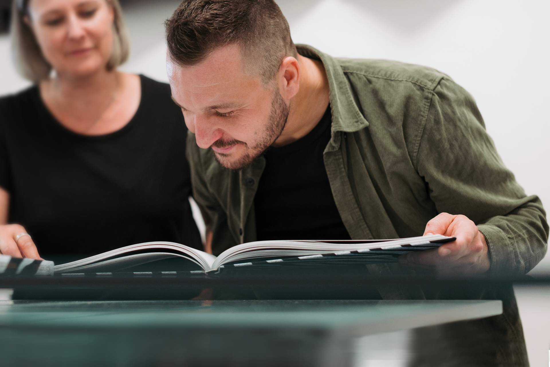 Zwei Kollegen der WARLICH DRUCK RheinAhr schauen sich ein Buch an.