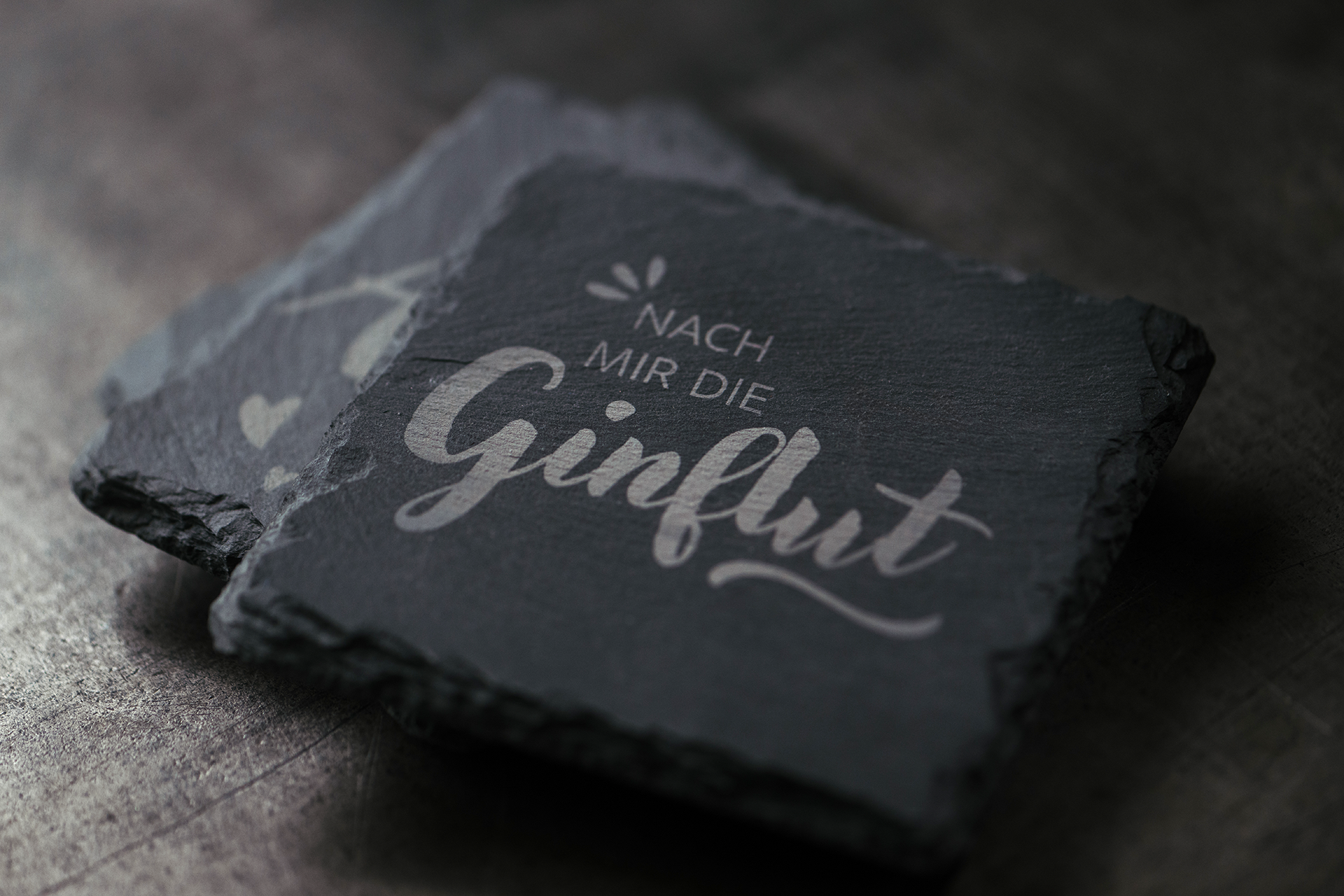 Schieferplatte mit dem Schriftzug „Nach mir die Ginflut“.