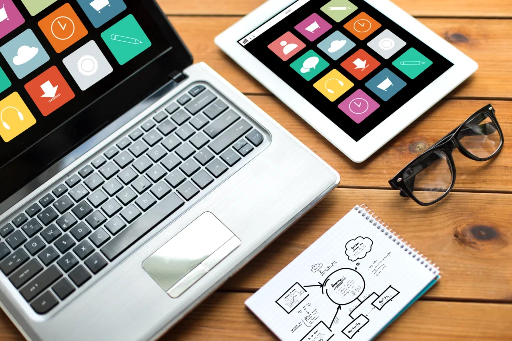 Laptop, Tablet mit App-Icons, Notizblock mit Sitemap und Brille – modernes und barrierefreies Webdesign-Konzept.