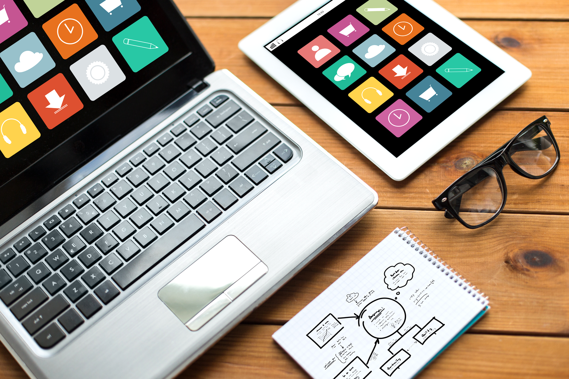 Laptop, Tablet mit App-Icons, Notizblock mit Sitemap und Brille – modernes und barrierefreies Webdesign-Konzept.