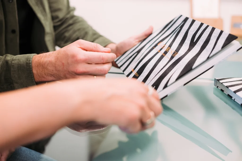 Zwei Mitarbeiter halten das „Zebrabuch“ in der Hand.